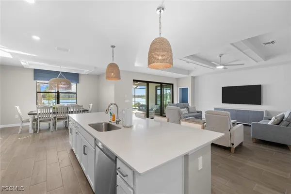 a large kitchen with sink a center island and furniture