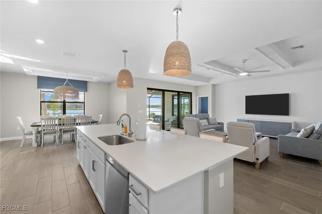 a large kitchen with sink a center island and furniture