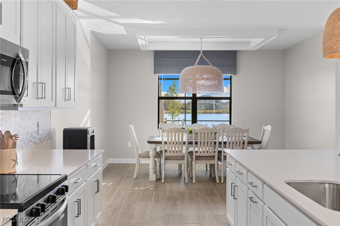 10575 Timber Creek Drive Fort Myers, FL 33913 - Photo 16 of 50 a kitchen with a dining table chairs and a sink