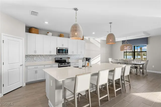 a kitchen with a dining table chairs sink and cabinets