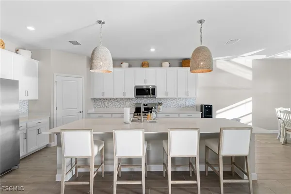 a kitchen with kitchen island a dining table and a wooden floor