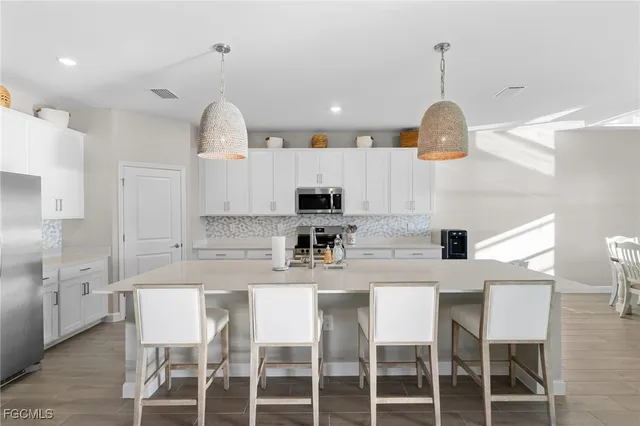 a kitchen with kitchen island a dining table and a wooden floor