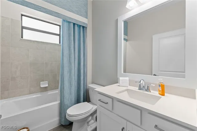 a bathroom with a sink a toilet a mirror a bathtub and shower