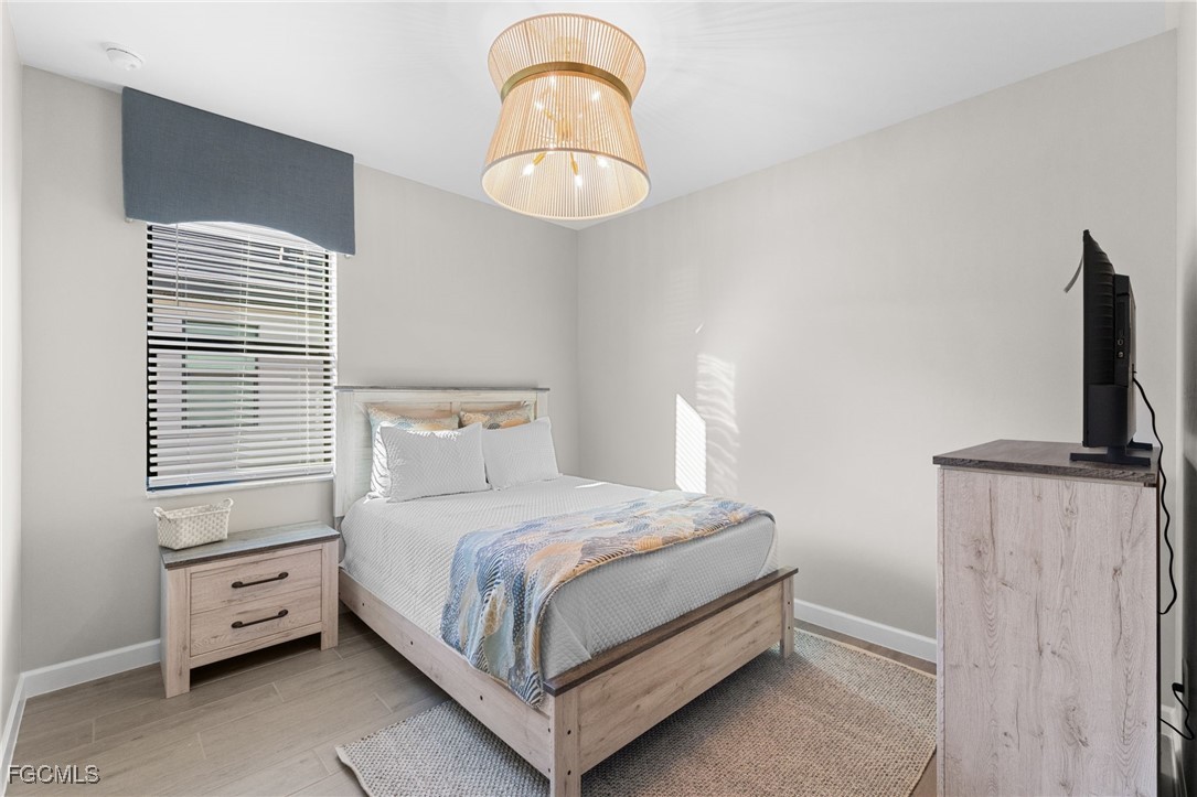 10575 Timber Creek Drive Fort Myers, FL 33913 - Photo 30 of 50 a bedroom with a bed and a chandelier