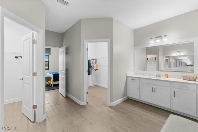 a spacious bathroom with a mirror and a sink