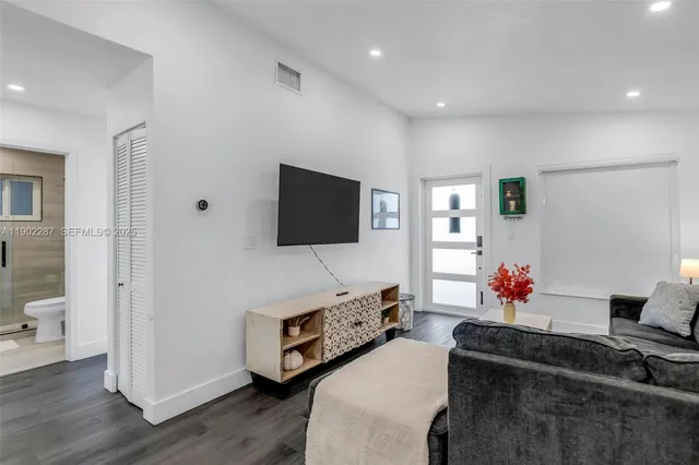a bedroom with a white bed and a flat screen tv