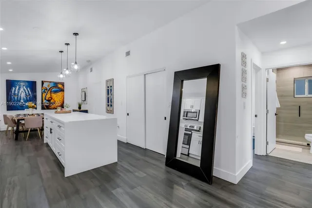 a bedroom with a bed a painting on the wall and a potted plant