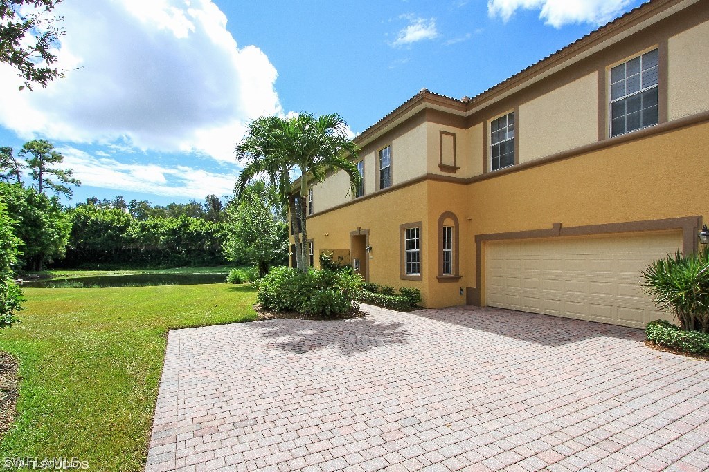 10110 Valiant Court, Unit 101 Fort Myers, FL 33913 - Photo 13 of 25 a front view of a house with a yard and garage
