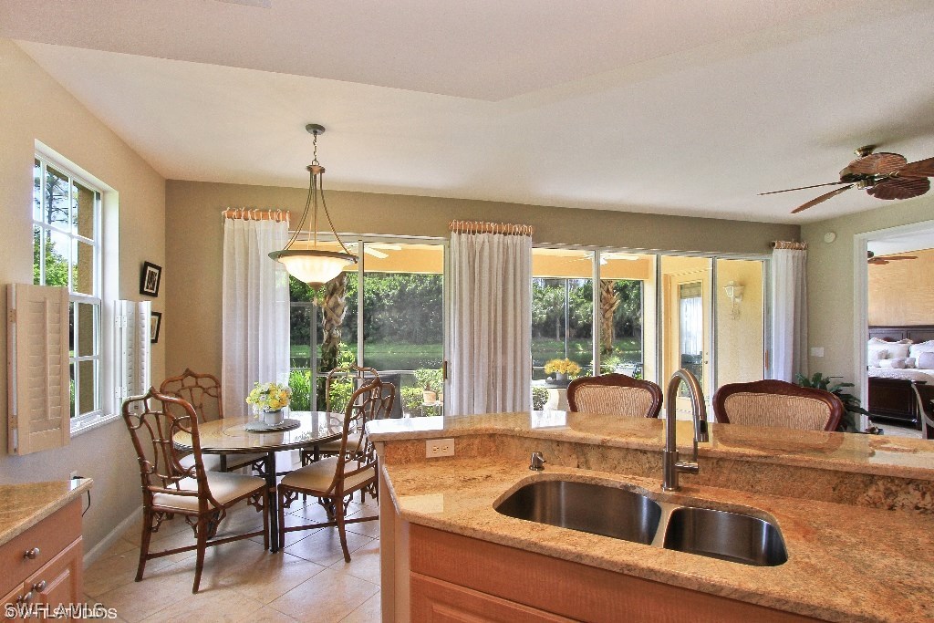 10110 Valiant Court, Unit 101 Fort Myers, FL 33913 - Photo 4 of 25 a kitchen with a sink and chairs