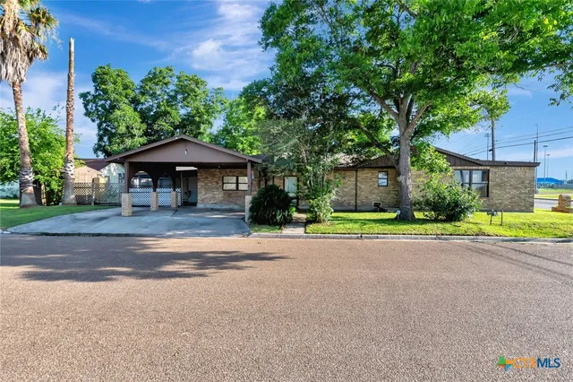 a house with a yard and a table under an umbrella