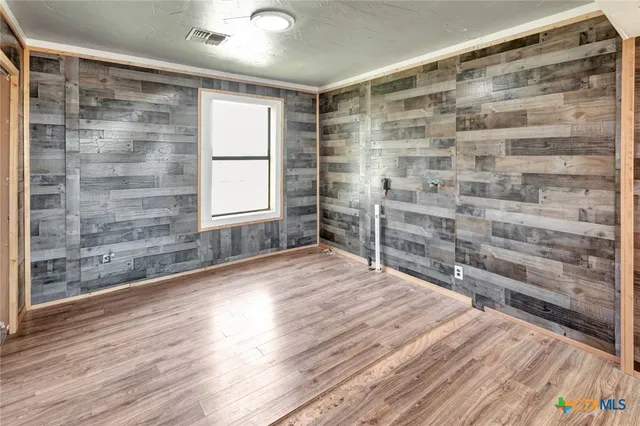 a area with wooden floor and windows