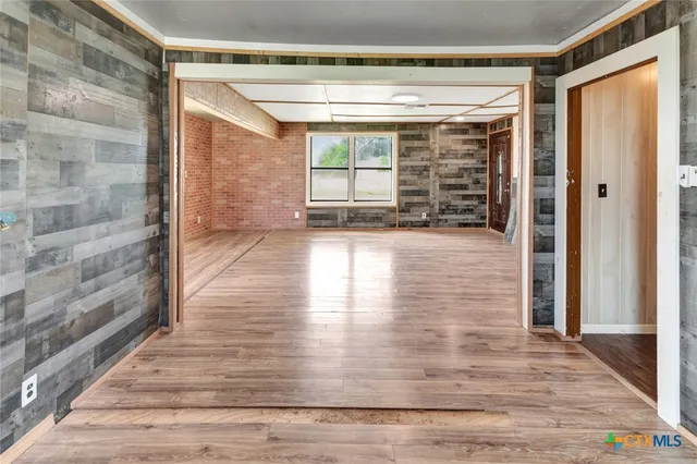 a view of empty room with window and wooden floor