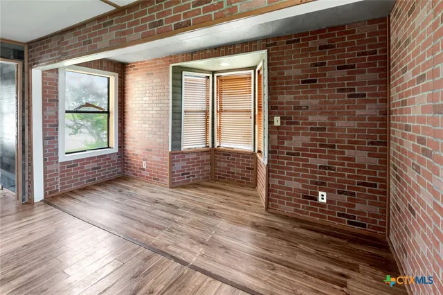 a view of a brick house with wooden floor and a window