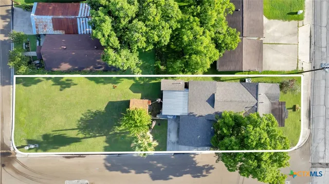 an aerial view of a house with a yard and lake view