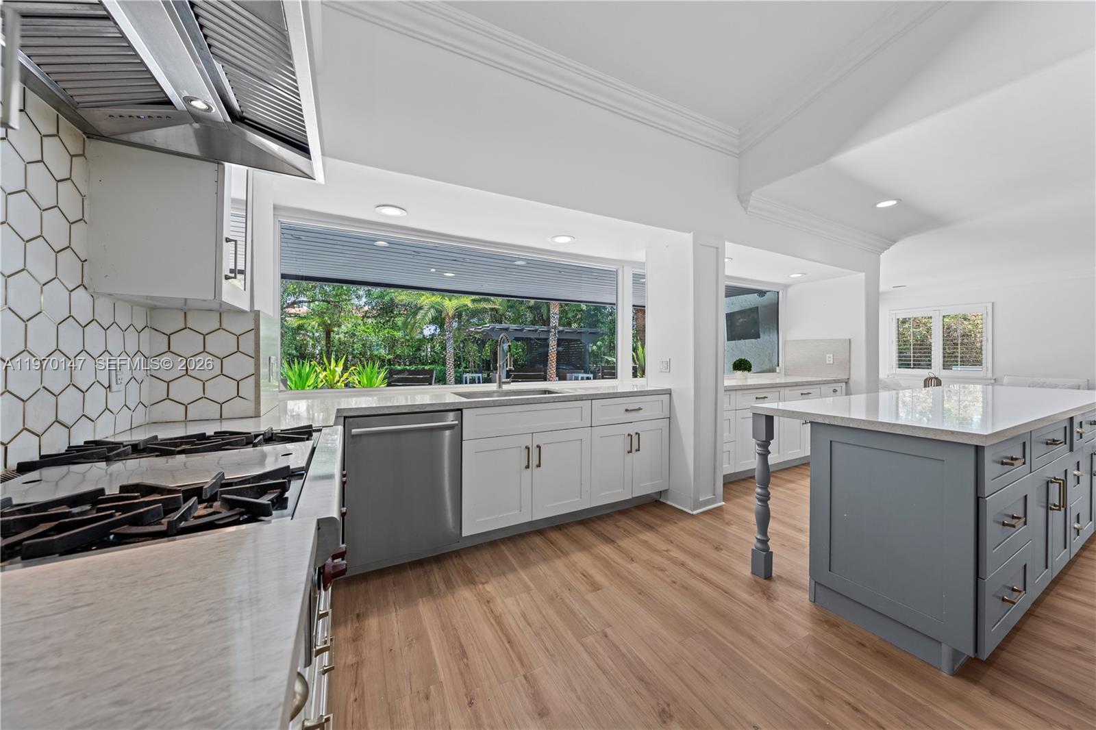8801 Southwest 124th Street Miami, FL 33176 - Photo 12 of 48 a kitchen with stainless steel appliances a stove a sink and white cabinets with wooden floor