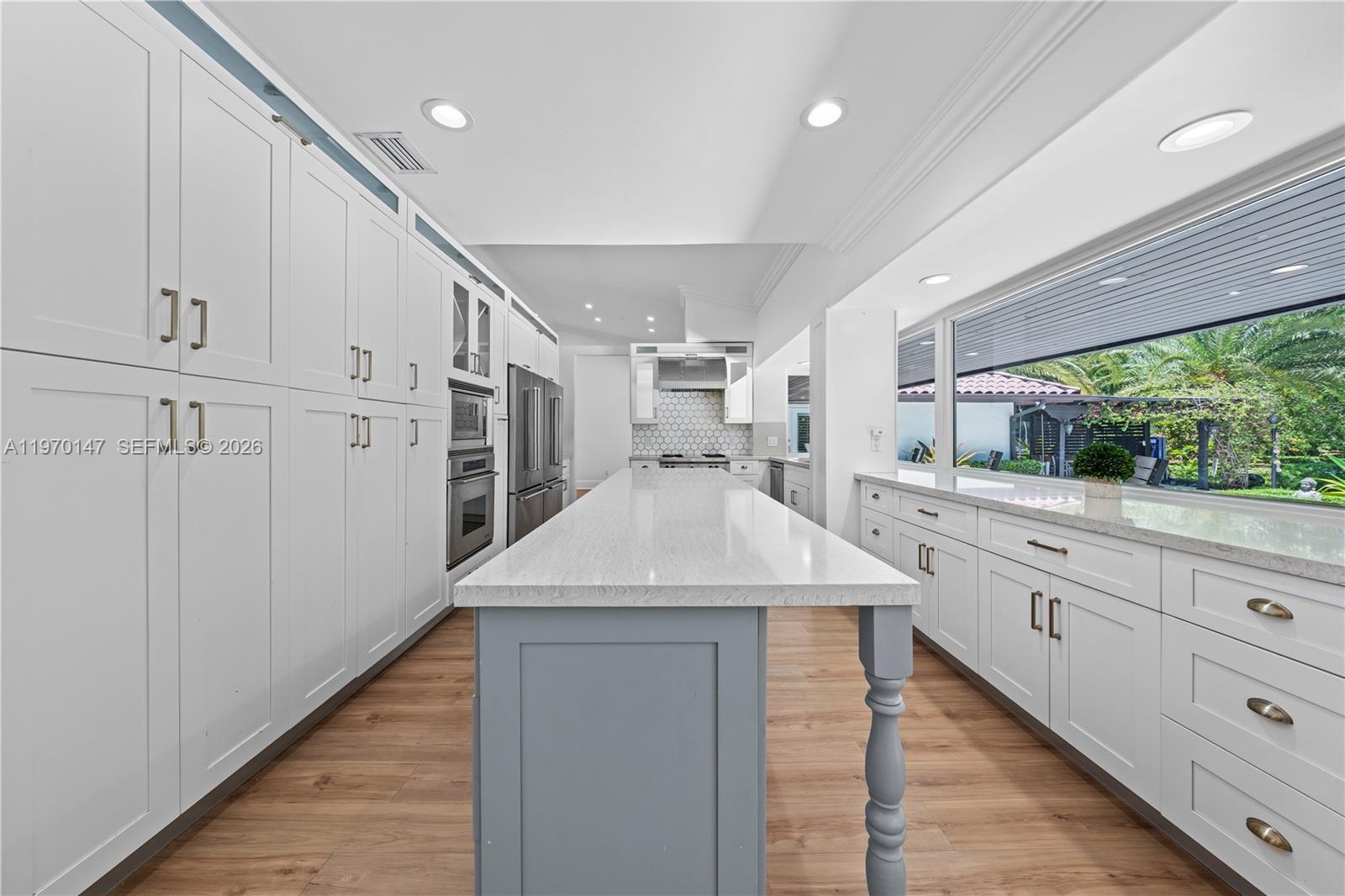 8801 Southwest 124th Street Miami, FL 33176 - Photo 13 of 48 a kitchen with a sink dishwasher and white cabinets with wooden floor