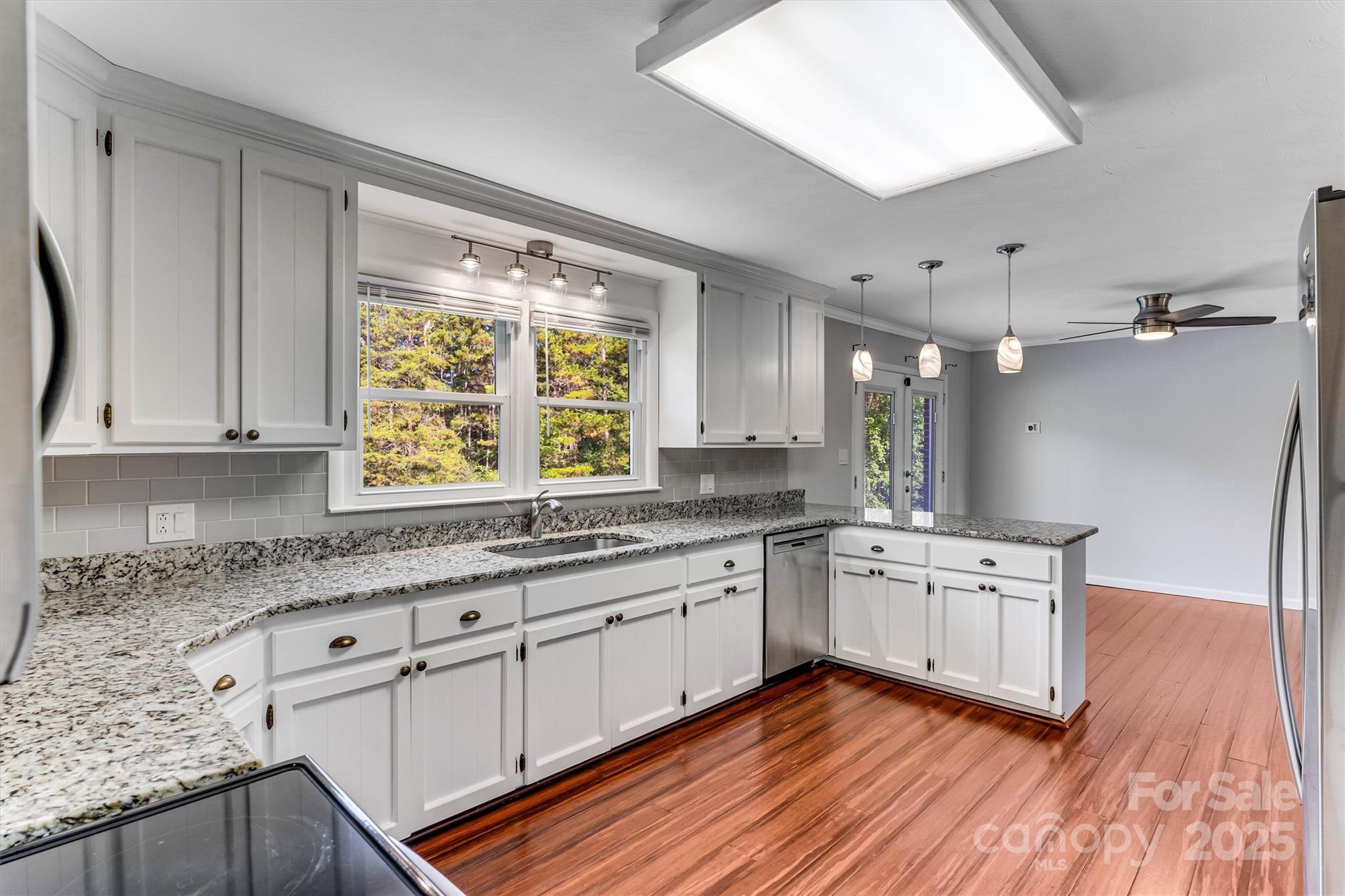 4015 Highway 18 Vale, NC 28168 - Photo 11 of 45 a kitchen with stainless steel appliances granite countertop wooden floors and white cabinets