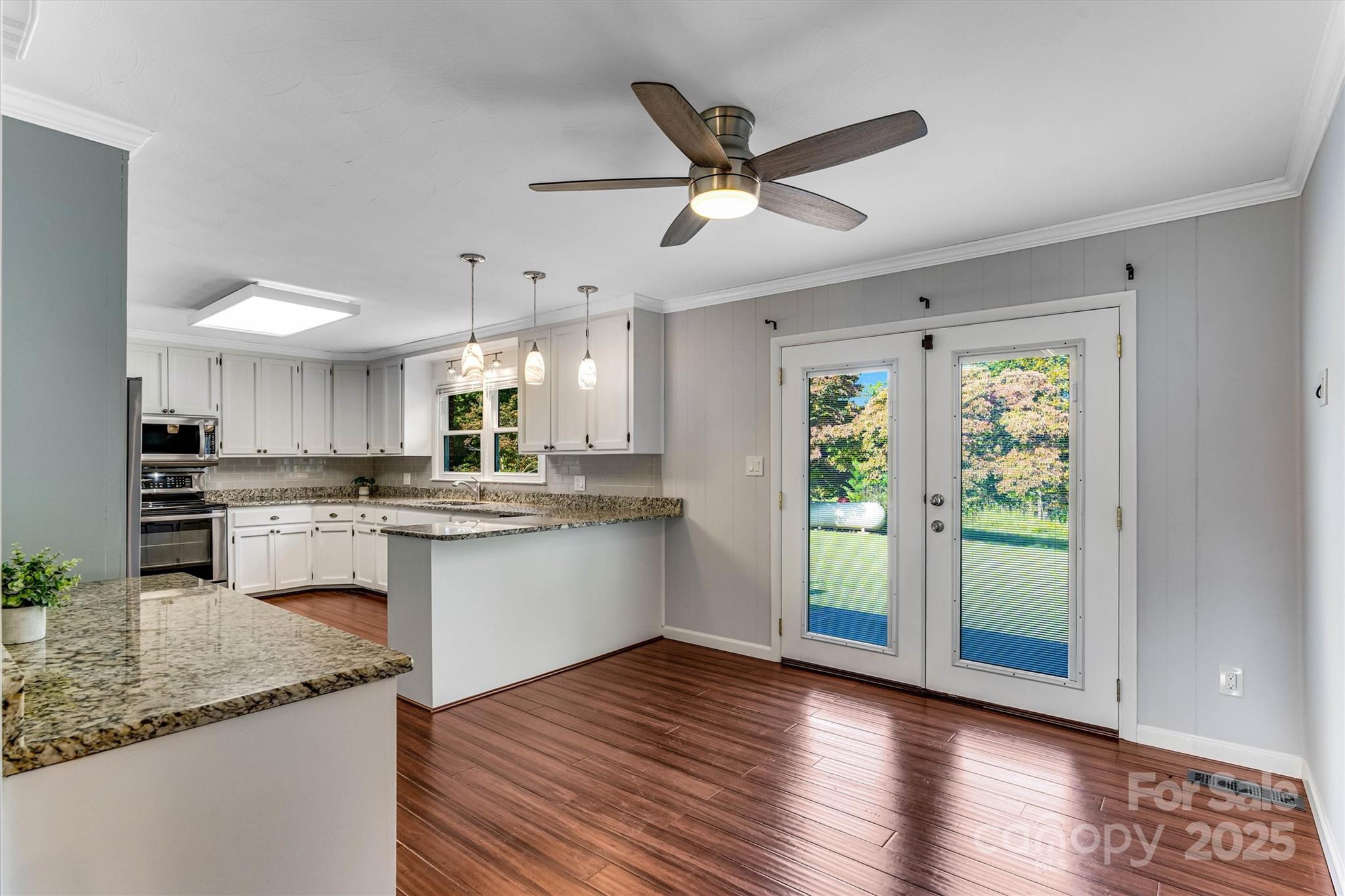 4015 Highway 18 Vale, NC 28168 - Photo 12 of 45 a kitchen with kitchen island granite countertop wooden floors white cabinets and stainless steel appliances