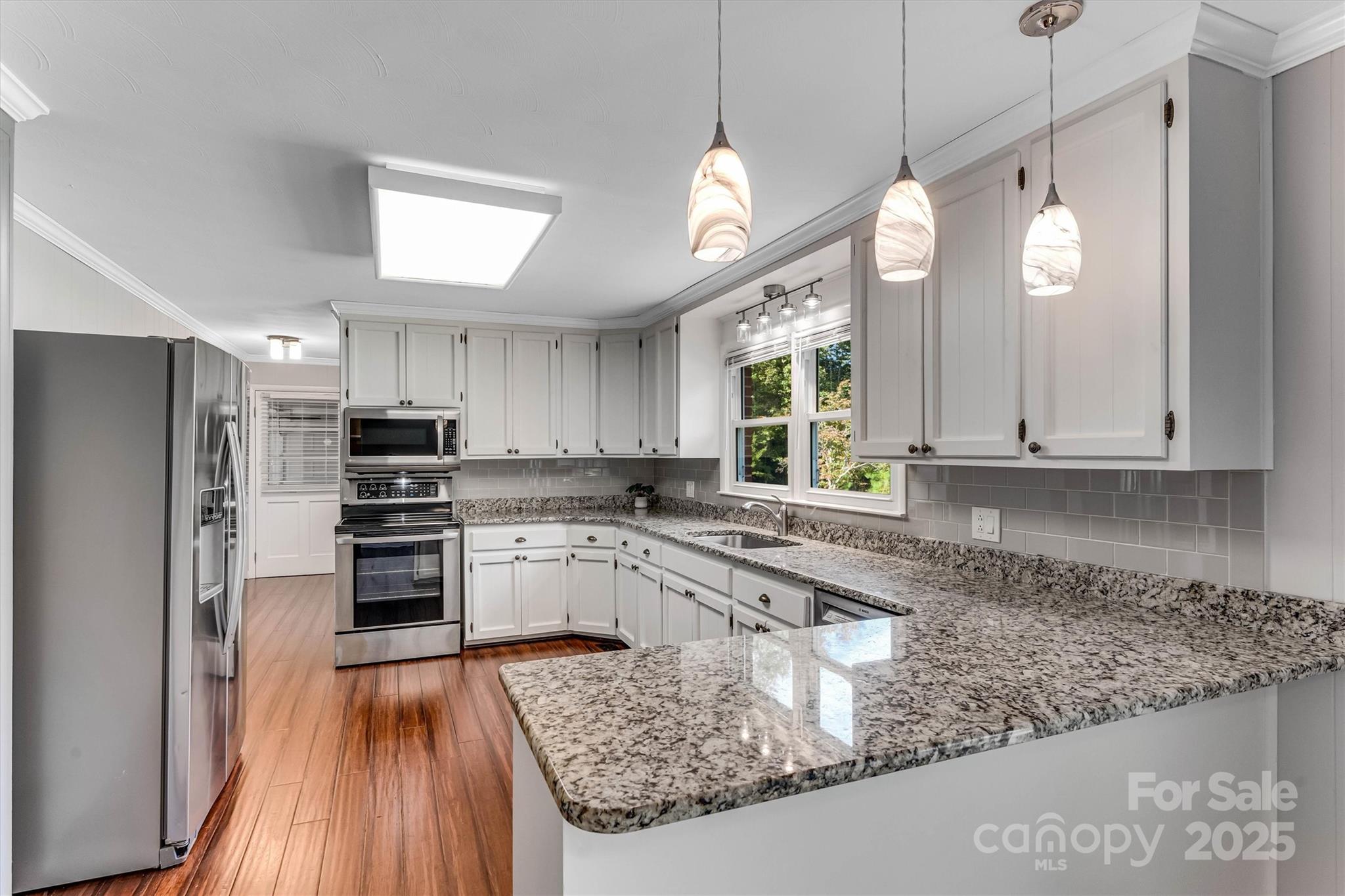 4015 Highway 18 Vale, NC 28168 - Photo 14 of 45 a kitchen with stainless steel appliances granite countertop a refrigerator a sink dishwasher a stove and white countertops with wooden floor