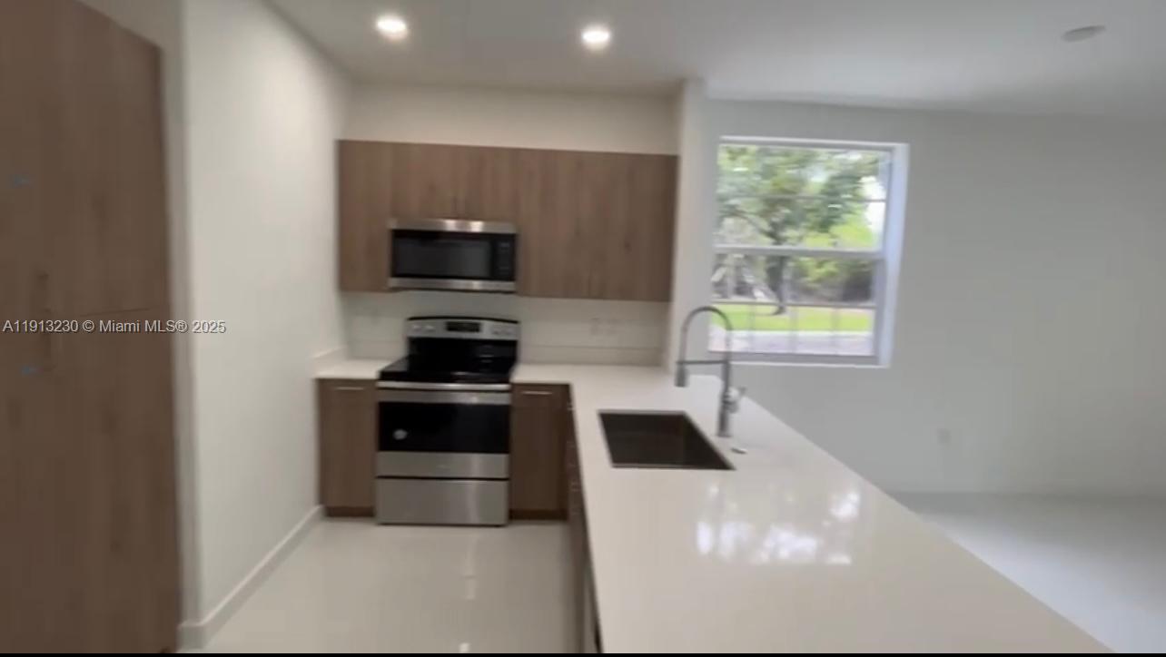 1350 Crystal Way, Unit 101 Delray Beach, FL 33444 - Photo 9 of 13 a kitchen with a stove and a microwave