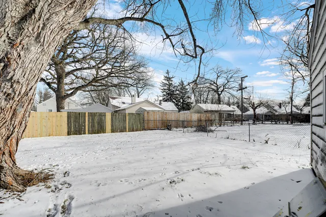 a front view of a house with a yard covered in snow