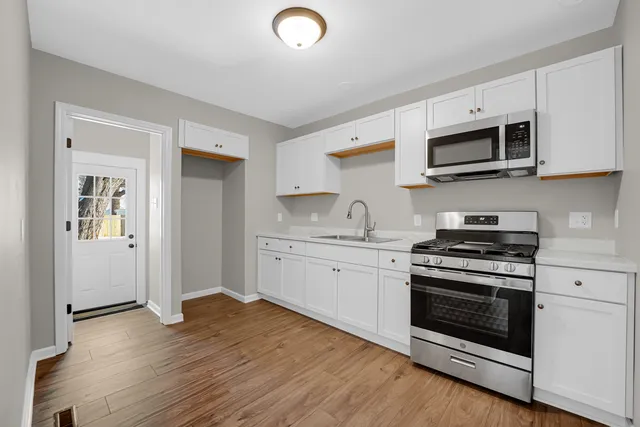 a kitchen with stainless steel appliances granite countertop a stove a sink and a microwave