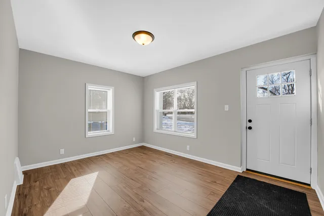 a view of an empty room and window and wooden floor