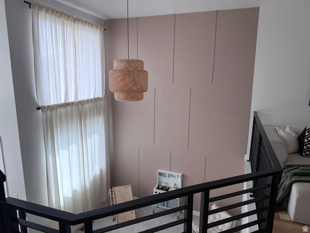 774 West 480 South American Fork, UT 84003 - Photo 35 of 76 Two-story room featuring a decorative accent wall with vertical paneling, a large suspended light fixture, and a black metal railing