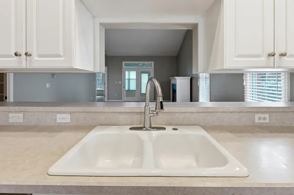 a view of a kitchen with a sink wooden floor and a window