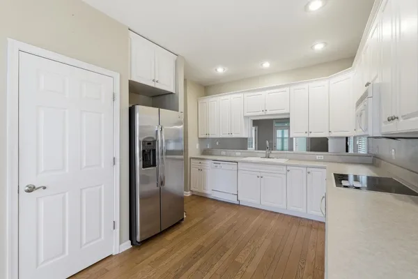a kitchen with white cabinets and a refrigerator