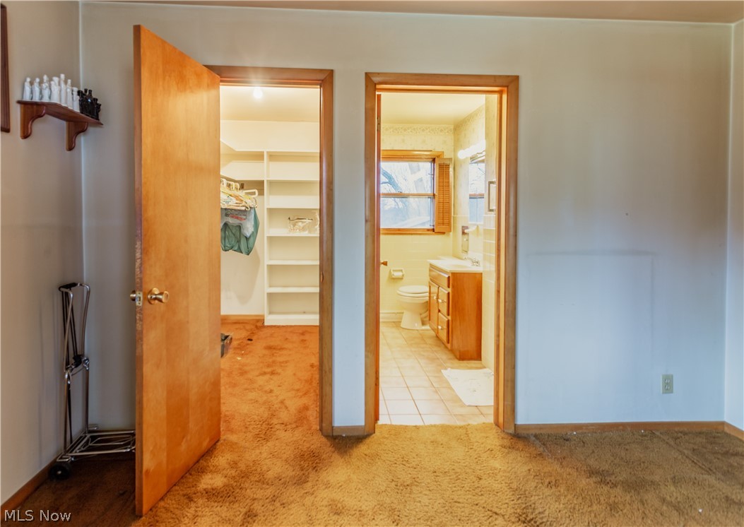 115 Lester Road New Franklin, OH 44319 - Photo 10 of 15 primary bedroom's walk in closet and bathroom