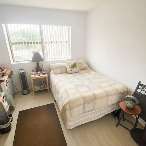 a bedroom with a bed chair and window