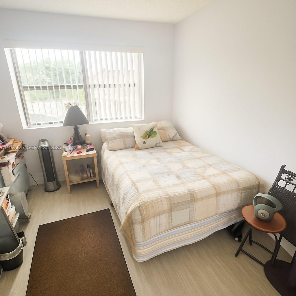 15530 Southwest 80th Street, Unit C301 Miami, FL 33193 - Photo 4 of 8 a bedroom with a bed chair and window