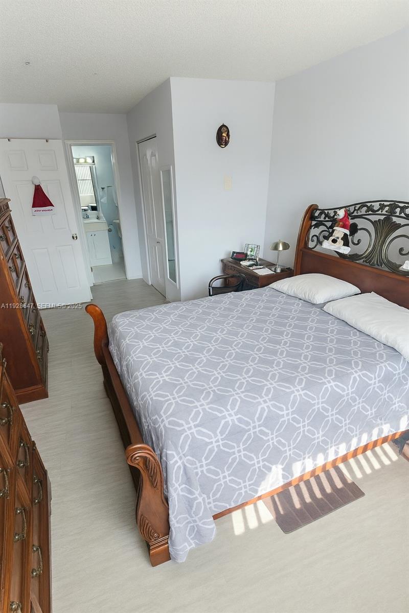 15530 Southwest 80th Street, Unit C301 Miami, FL 33193 - Photo 6 of 8 a bedroom with a bed and a dresser