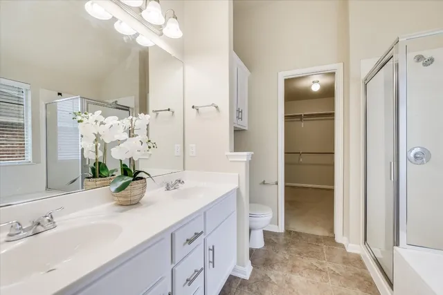 a spacious bathroom with a double vanity sink mirror and shower