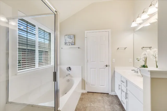 a bathroom with a tub sink and mirror