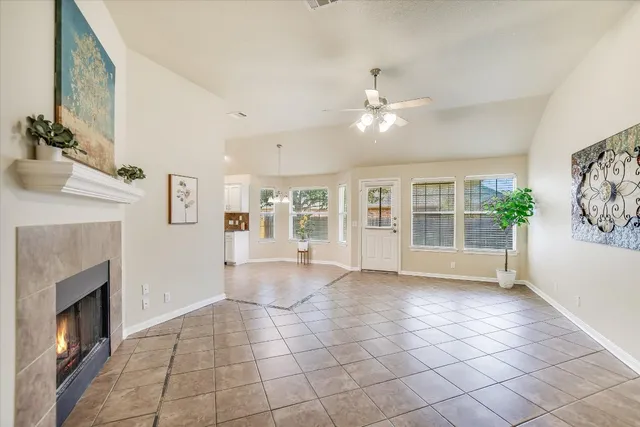 a view of an empty room with a fireplace and a window
