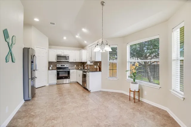 a kitchen with stainless steel appliances kitchen island granite countertop a refrigerator and a stove top oven
