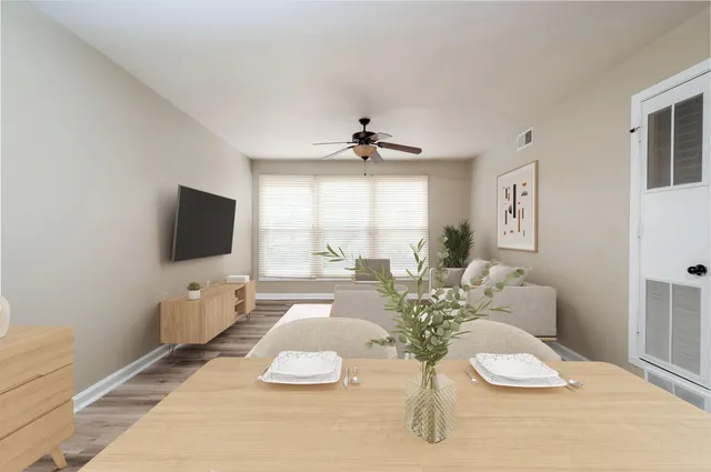 a living room with furniture a flat screen tv and a large window
