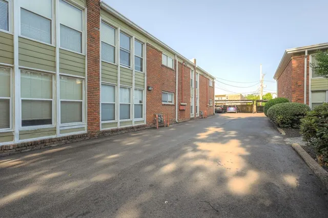 a view of a house with backyard and trees