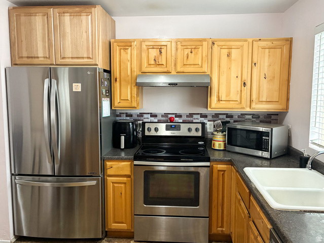 297 West Bricker Road Draper, UT 84020 - Photo 2 of 25 Kitchen featuring stainless steel appliances, dark countertops, tasteful backsplash, and light wood finish cabinets