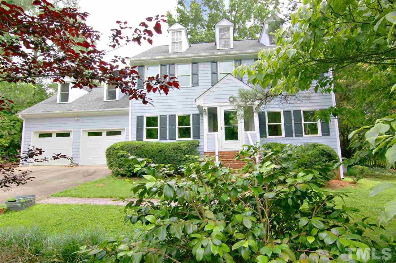 a front view of a residential houses with yard and green space