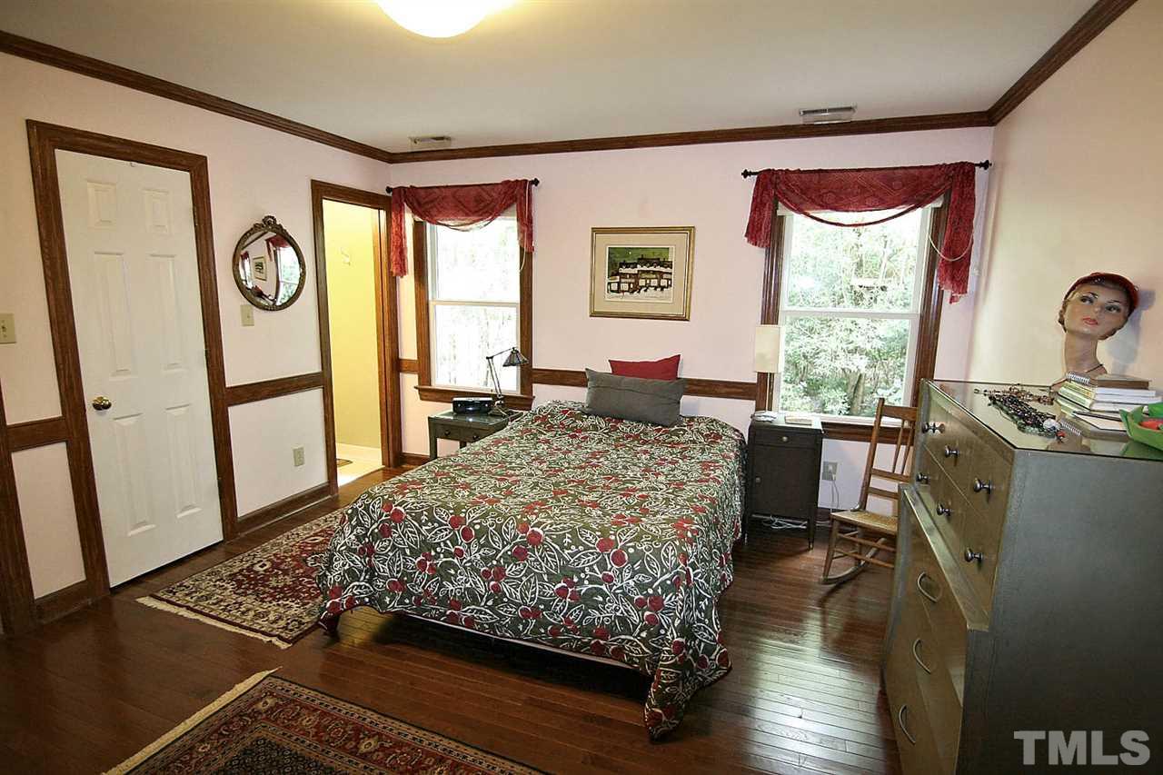 206 Lawrence Road Cary, NC 27511 - Photo 13 of 25 a bedroom with a bed and wooden floor