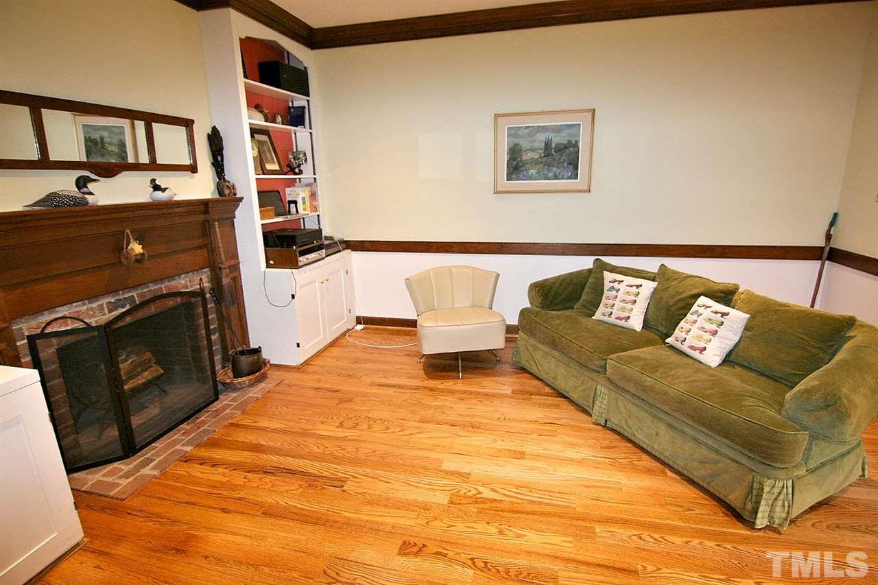 206 Lawrence Road Cary, NC 27511 - Photo 8 of 25 a living room with a couch and a stove with wooden floor