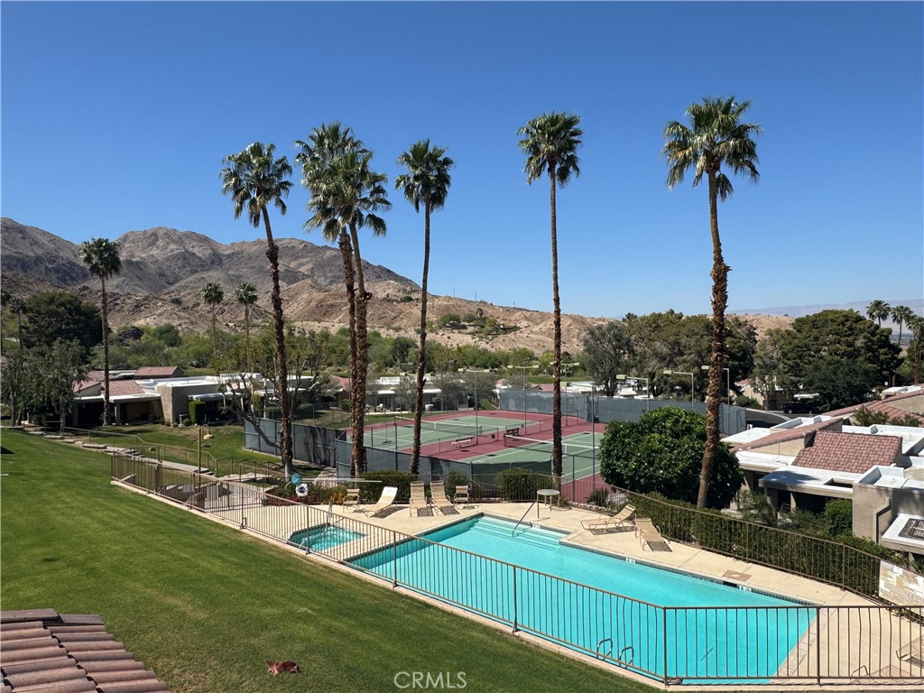 72400 Ridgecrest Lane Palm Desert, CA 92260 - Photo 2 of 13 a view of a swimming pool with a table and chairs