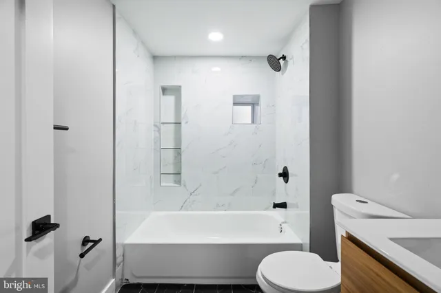 a bathroom with a bathtub toilet and a shower