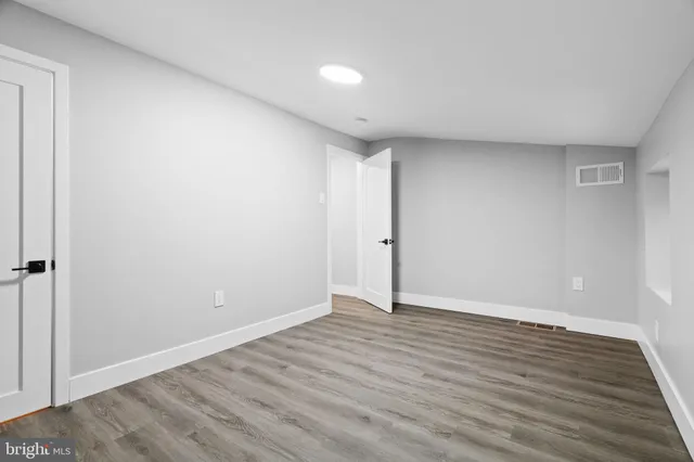 a view of an empty room with wooden floor