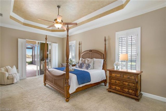 a bedroom with a large bed and a chandelier