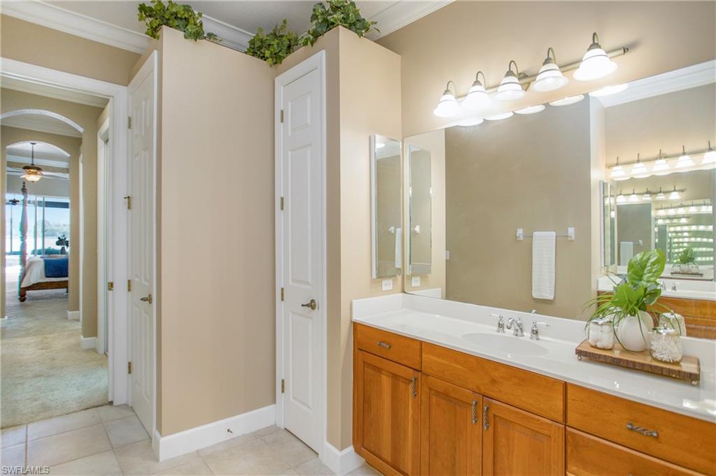 9807 Nickel Ridge Circle Naples, FL 34120 - Photo 16 of 50 a bathroom with a granite countertop sink a large mirror and a shower