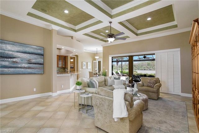 a living room with furniture a chandelier and a large window